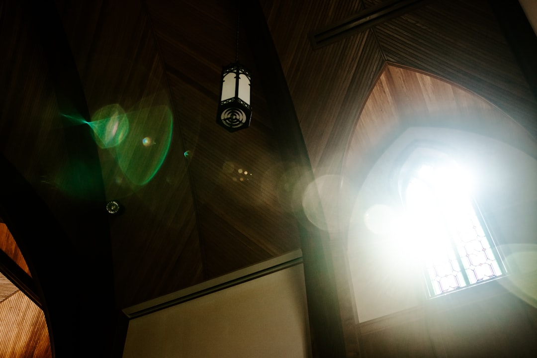 a light shines through a window in a church