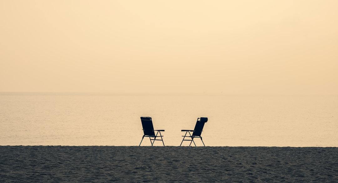 two empty chairs on the beach