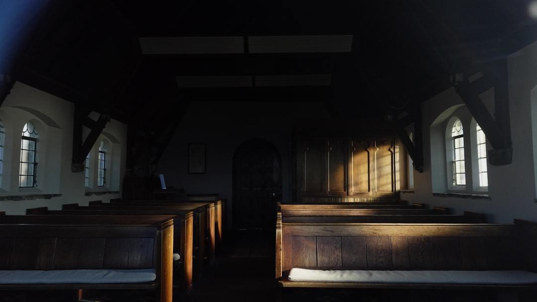 Empty church pews with sunlight streaming through windows