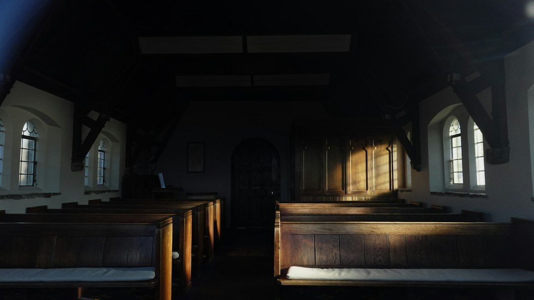 Empty church pews with sunlight streaming through windows