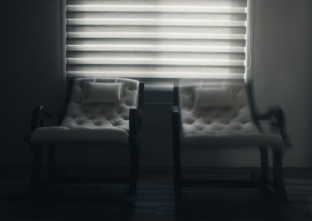 white window blinds near black wooden chair